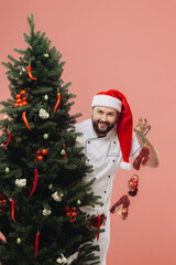 The concept of cooking and Christmas holidays. A chef in a Santa hat on the background of a Christmas tree.