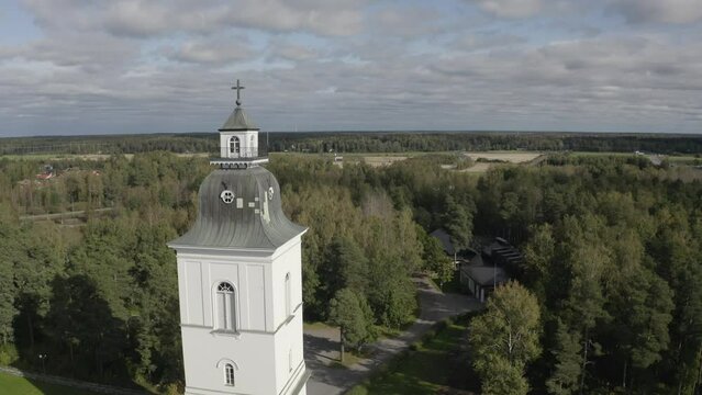 Drone view of Korsholm Church bell tower with green dense woods in the background in Vaasa, Finland.