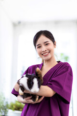 Woman holding cute fluffy Bunny at home. Friendship with Easter Bunny. A beautiful young woman with her bunny. Beautiful Asian woman Hug her rabbit