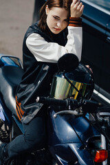 Fototapeta na wymiar beautiful young female motorcyclist sits on a motorcycle.