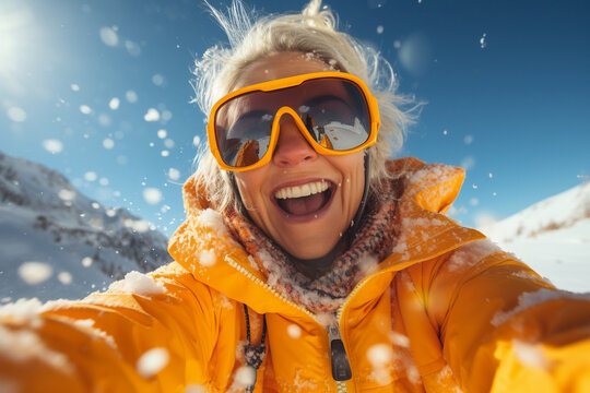 Smiling Winter Enthusiast Captures Selfie with Snow-Capped Mountains Under Sunlight
