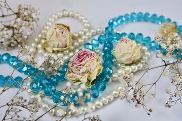 White and blue beads with dried rose buds