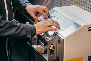 Hands of electrician working on cutting wires machine