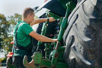 Young mechanic repair tractor outdoor