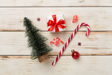 Miniature christmas tree with gift box and decor on wooden background