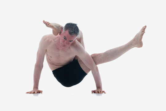 Eka pada sirsasana. (One Leg Behind the Head Pose), Ashtanga yoga  Side view of man wearing sportswear doing Yoga exercise against white background. Horizontal image.