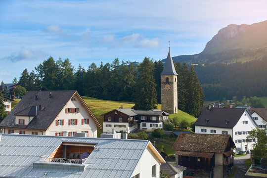 Churwalden village in Switzerland. Formerly Parpan. Beautiful swiss alpine countryside with a medieval bell tower and Rothorn mountain on background.