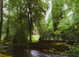 Fototapeta na wymiar Bad Wildbad. Kurpark Rundgang. Englische Kirche zwischen hohen Bäumen inmitten einer Grünfläche Am lauf der Fluss Enz