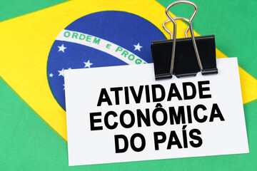 On the flag of Brazil lies a business card with the inscription - economic activity of the country