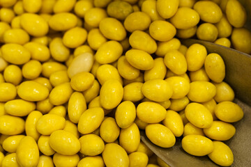 There are candies on the counter - peanuts in yellow glaze and a spoon.