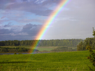Scenic view of rainbow over field against sky