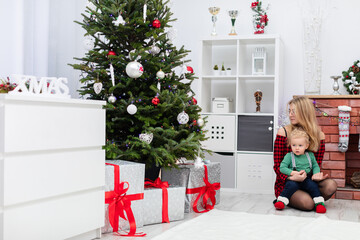 Blonde woman with loose hair holds a little boy on her lap