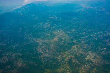 Fototapeta na wymiar Mountainous and hilly terrain from an airplane flight