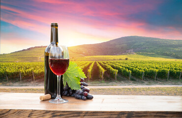 Red wine bottle and wine glass on wodden barrel. Beautiful Tuscany background. High quality photo - 660656367