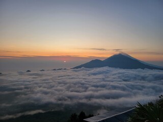 Batur mountain top sunrise above the cloud
