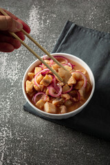 fish ceviche with onions and pepper. traditional peruvian food with tigra milk
