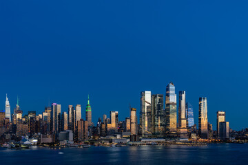 Fototapeta na wymiar Aerial New York City skyline from New Jersey over the Hudson River with the skyscrapers of the Hudson Yards district at night. Manhattan, Midtown, NYC, USA. A vibrant business neighborhood