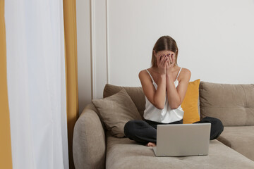 Portrait of young worried, depressed woman working from home. Writer, blogger, freelancer or...