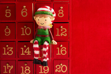 Christmas advent calendar with an elf and gifts on red background