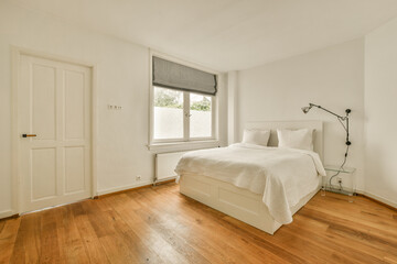 Fototapeta na wymiar a bedroom with wood floors and white walls, including a large bed in the corner of the room on the right is a window
