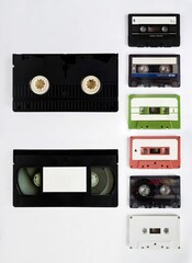 A nostalgic snapshot of 80s and 90s treasures; a collection of colourful audio cassettes and VHS cassette tapes, relics of analog entertainment in a digital world.