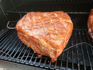 Pork Shoulder, with a thermometer, being smoked in the smoker, 