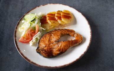 Grilled salmon dish with garnish on a rustic background