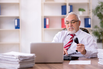 Fototapeta premium Old male employee and too much work in the office