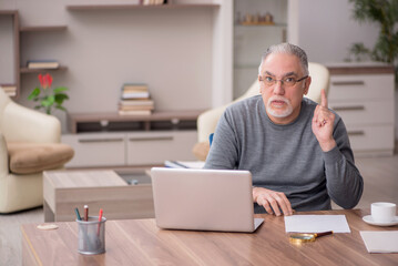 Old male employee working from home during pandemic