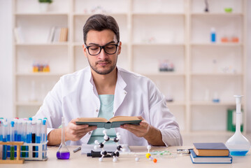 Fototapeta premium Young male chemist sitting at the lab