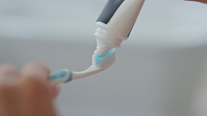 Lady hand applying toothpaste brush indoors closeup. Dental hygiene healthcare