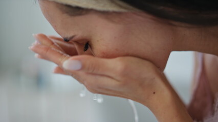 Calm lady cleaning face home close up. Satisfied woman splashing water on skin
