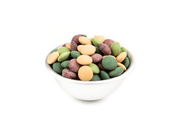 Bowl of forest green brown tan camoflage colored candy coated chocolate pieces side view