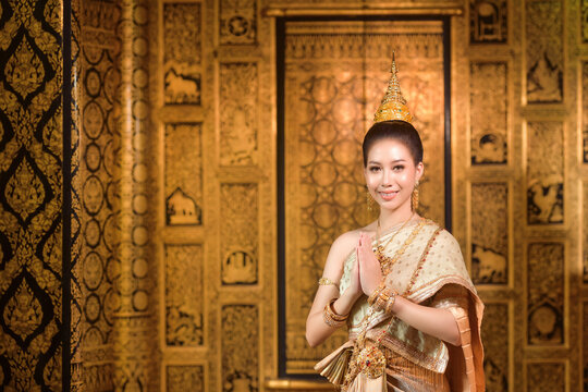 Smiling woman standing with her hands in prayer position, Thailand