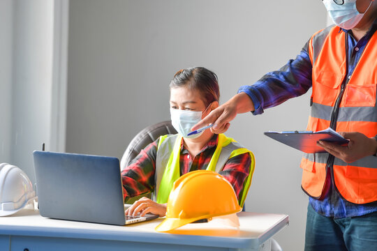 Two building inspectors in an office discussing a construction project