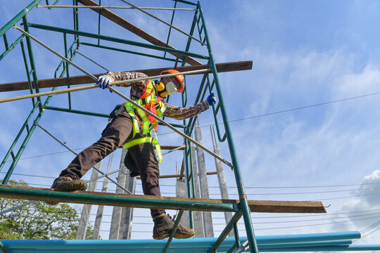 Low angle view of a Construction worker in a face mask standing on scaffolding, Thailand