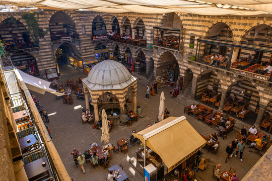 DIYARBAKIR, TURKEY, 05 OCTOBER 2023: View of the Hasanpasa Khan, medieval historic building where people have breakfast and small shops, the central of Diyarbakir,