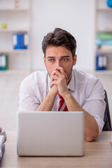 Young male employee and too much work in the office