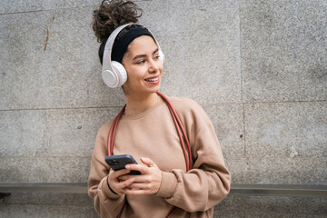 One young sporty woman with headphones use mobile phone app for music