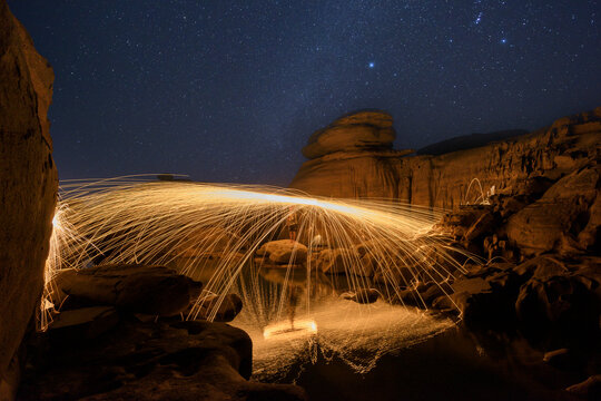 Person Spinning wire wool in canyon, Sam Pan Bok, Ubon Ratchathani, Thailand