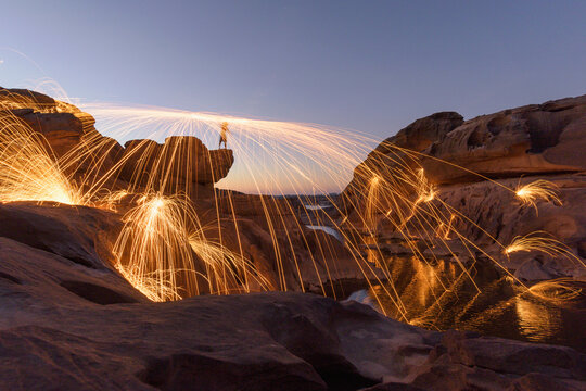 Person Spinning wire wool in canyon, Sam Pan Bok, Ubon Ratchathani, Thailand