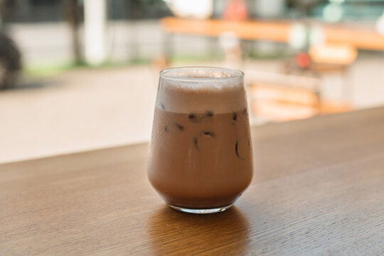 Mocha coffee on a wooden table by a window in a cafe