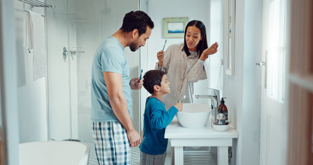 Parents, child and brushing teeth in family home bathroom while learning or teaching dental hygiene. A woman, man and kid with toothbrush and toothpaste for health, cleaning mouth and wellness - Powered by Adobe
