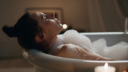 Romantic woman chilling foam bath at home closeup. Groomed naked girl having spa