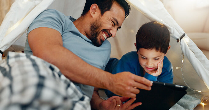 Bonding, tablet and father in a tent with kid watching a movie, video or show online. Happy, smile and young dad networking on social media with boy kid on digital technology in blanket fort at home. - Powered by Adobe