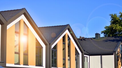 Suburban neighborhood with condominium complex. Suburban area with modern geometric family houses. Row of family houses against blue sky.