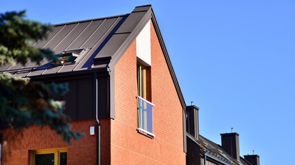 Suburban neighborhood with condominium complex. Suburban area with modern geometric family houses. Row of family houses against blue sky.