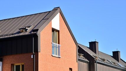 Suburban neighborhood with condominium complex. Suburban area with modern geometric family houses. Row of family houses against blue sky.