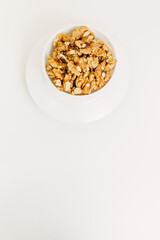 There are peeled walnuts in a white plate.