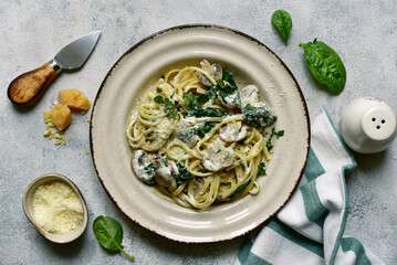 Pasta with spinach and mushrooms in a cream sauce. Top view with copy space.